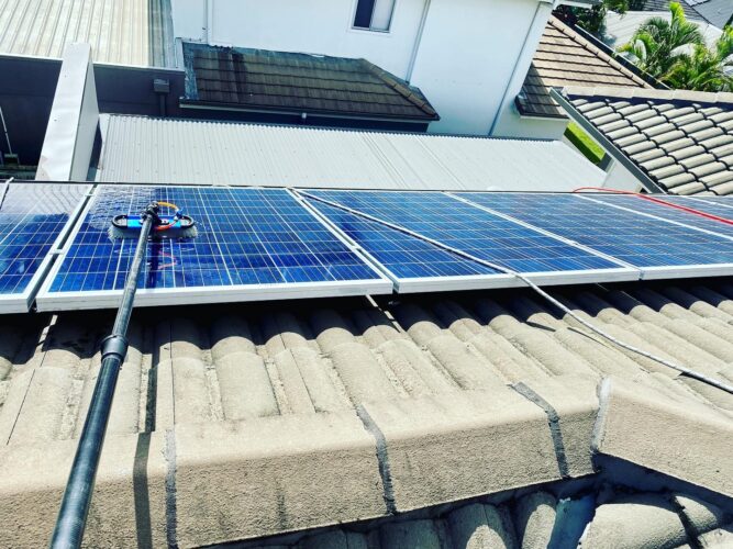Solar panel cleaning with a water-fed pole — pure water delivered to a soft brush