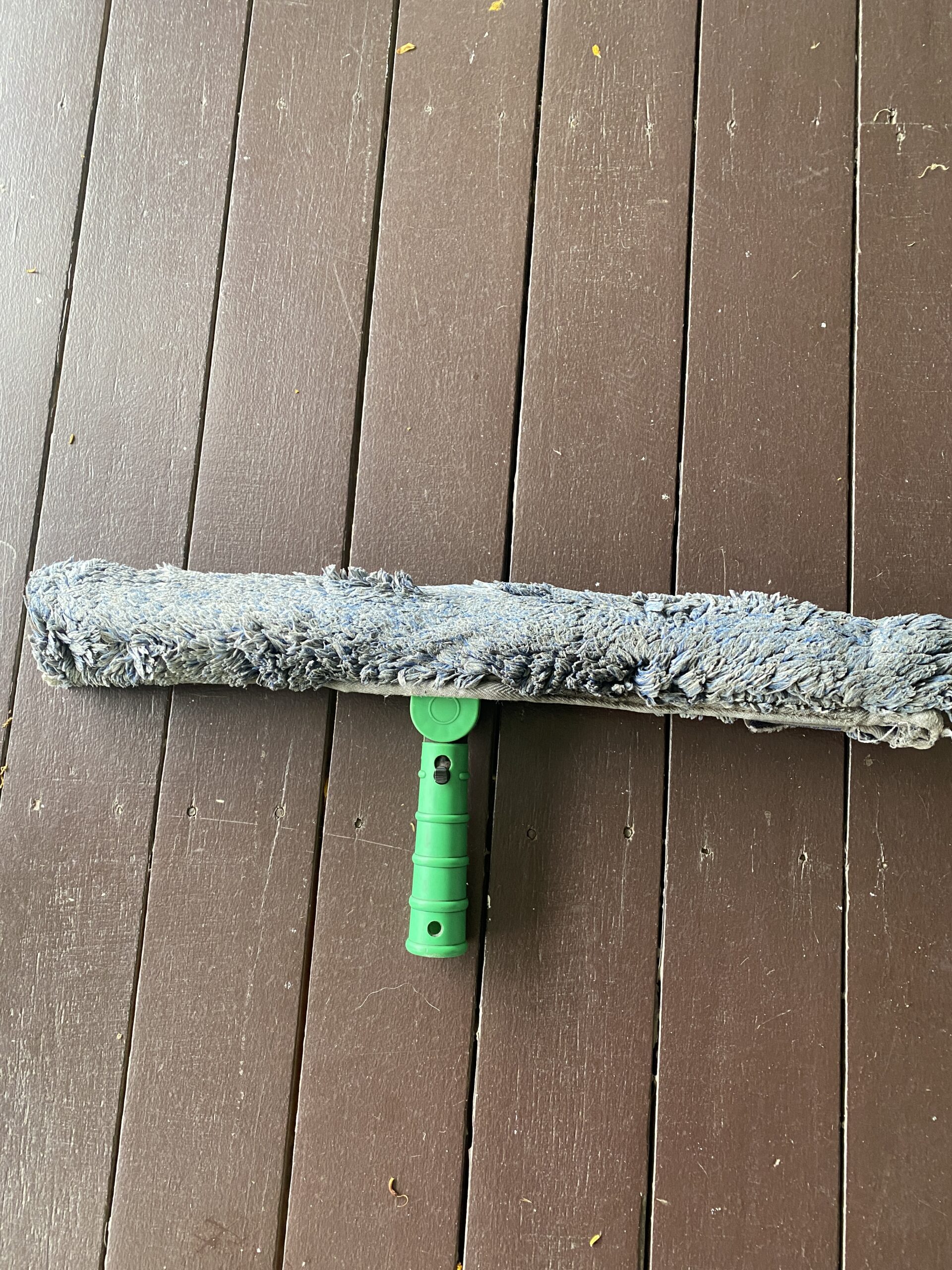 Window cleaning mop — applying soapy solution to the glass